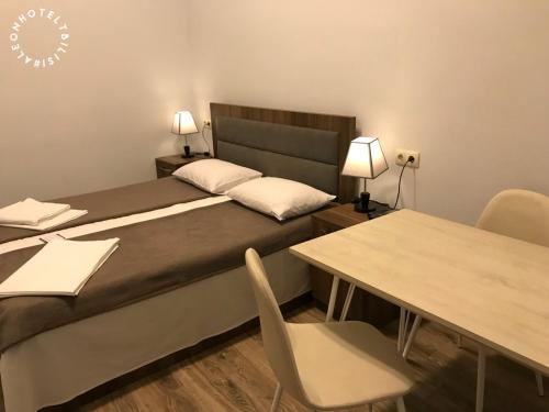 a bedroom with a bed and a table with chairs at Aleon Hotel in Tbilisi City