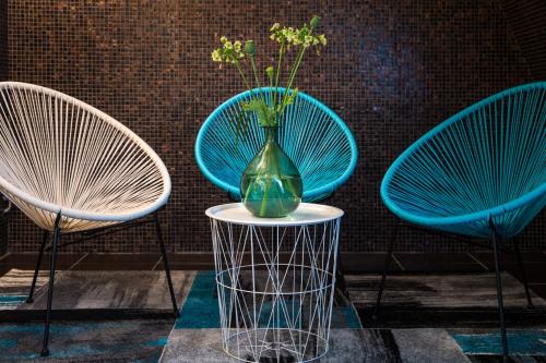 a vase sitting on a table next to two chairs at Home Hotel Carlscrona in Karlskrona