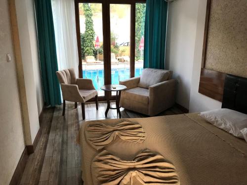 a bedroom with a bed and a living room with a pool at Oskar Thermal Hotel in Pamukkale