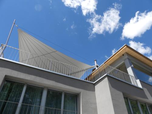 a building with a pitched roof with a balcony at Laagers Hotel Garni in Samedan