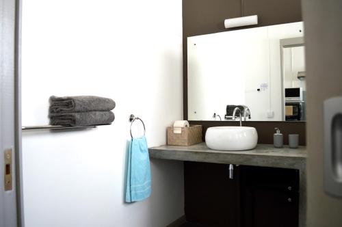 La salle de bains est pourvue d'un lavabo et d'un miroir. dans l'établissement Summerdays Studios, à Coteau Raffin