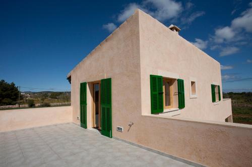 a building with green shutters on it at Finca Sa Carrotja in Porto Cristo
