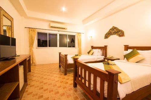 a hotel room with two beds and a television at Rajapruek Samui Resort - SHA Plus in Lipa Noi