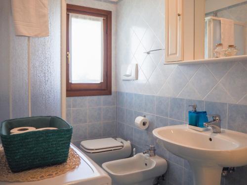 La salle de bains est pourvue d'un lavabo et de toilettes. dans l'établissement LA BRIGATA APARTMENTS Yellow House, à Cavallino-Treporti