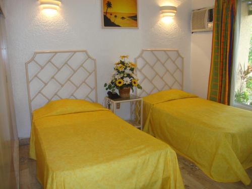 Ein Bett oder Betten in einem Zimmer der Unterkunft Sands Acapulco Hotel & Bungalows