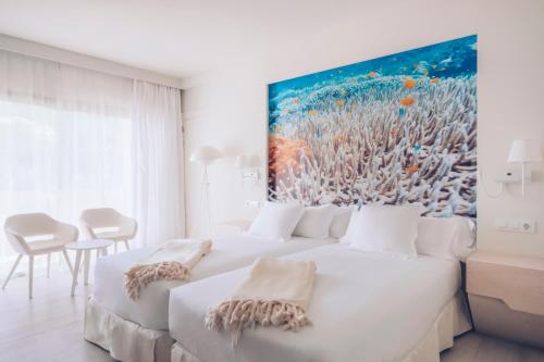 a bedroom with two beds and a painting on the wall at Iberostar Selection Fuerteventura Palace in Morro del Jable