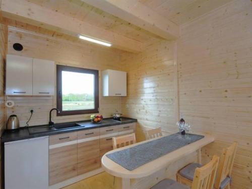 a kitchen with a sink and a table in a room at Domki Korsarz Gaski in Gąski