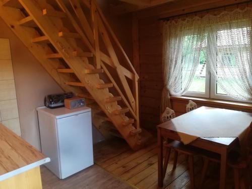 a kitchen with a staircase and a refrigerator in a cabin at Magellan Domki in Cisna