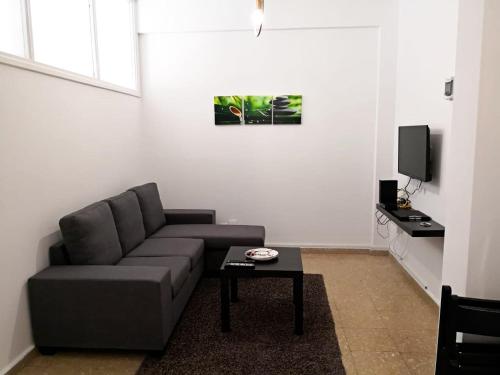 uma sala de estar com um sofá e uma mesa de centro em Cheerful Apartment in Nicosia em Yukarı Lakatamya