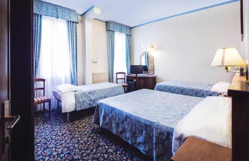 a hotel room with two beds and a television at Hotel Al Sole Terme in Abano Terme