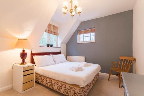 a bedroom with a bed with a lamp and a chair at UNIQUE COUNTRY COTTAGE Nr NATURE RESERVE Sleeps 4 in London