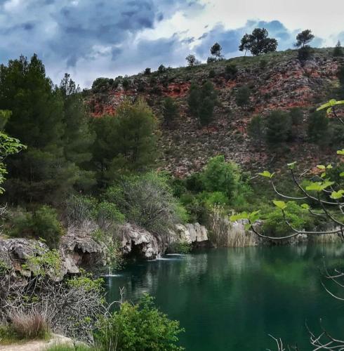 a river in the middle of a hill with green water at Casa Rural Villa Sem Sem in Ossa de Montiel