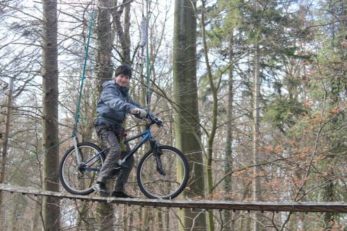 a man riding a bike on a bridge in the woods at Haus Feldmann in Ranzow