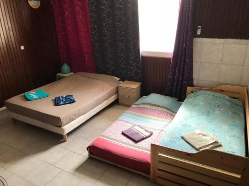 two twin beds in a room with a window at L'Escale du Mouillage in Saint-Pierre