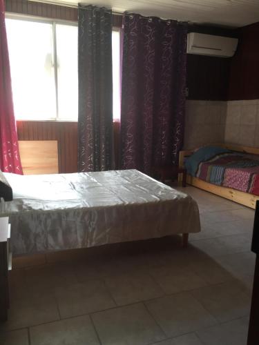 a bedroom with a bed and two windows at L'Escale du Mouillage in Saint-Pierre