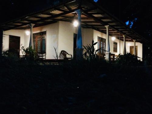 a white house with a light on top of it at night at Sigiriya Lahiru Homestay in Sigiriya