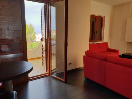 - un salon avec un canapé rouge et une table dans l'établissement Casa Viktoria, à San Nicola Arcella