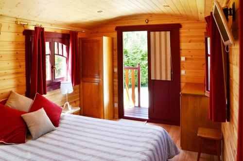 a bedroom with a bed and a door to a balcony at Logis Hôtel-Restaurant Le Relais in Hauterives