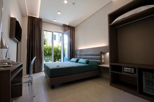 a bedroom with a bed and a large window at Hermes Hotel in San Vito lo Capo