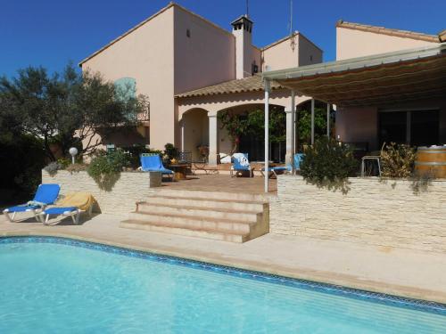 une maison avec une piscine devant une maison dans l'établissement Les Bougainvillées de Camargue, à Villetelle