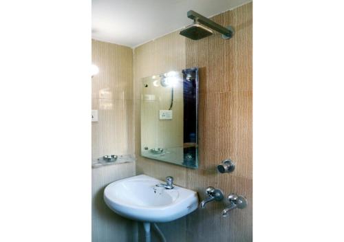 uma casa de banho com um lavatório e um espelho em Inderlok Hotel em Chandīgarh