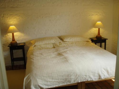 a bedroom with a bed with two lamps on tables at Top Parts Bed & Breakfast in Abbotsbury