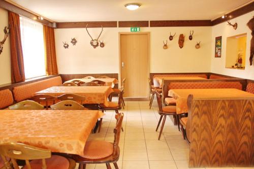 a restaurant with rows of tables and chairs and a room at Zur Post in Lackenhof