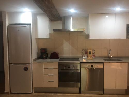 a kitchen with a refrigerator and a stove top oven at Precioso apartamento centro pueblo in Ribes de Freser