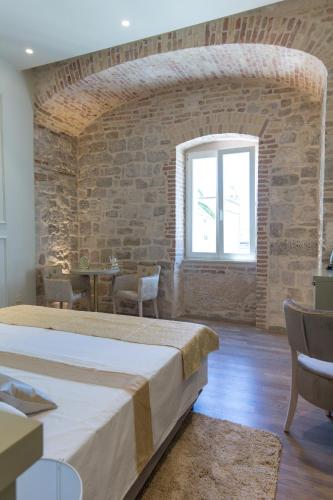 a room with a bed and a brick wall at Riva Palace in Split