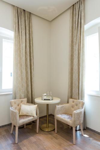 a dining room with a table and two chairs at Riva Palace in Split
