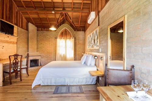 聖安東尼奧－杜皮尼亞爾的住宿－Pousada Villa Campestre，卧室配有一张床和一张桌子及椅子