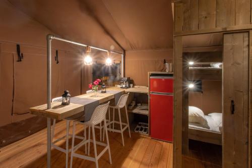 a room with a table and chairs and bunk beds at Lodge Holidays - Glamping Heart of Nature in Ribnik