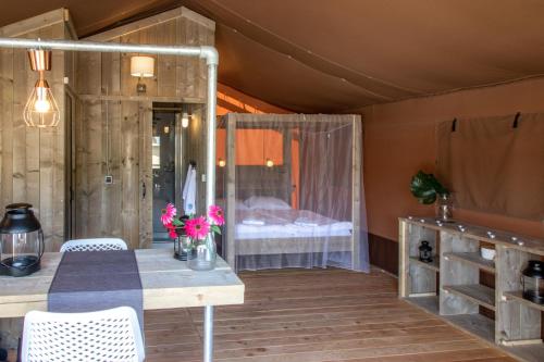 a room with a bed and a table and chairs at Lodge Holidays - Glamping Heart of Nature in Ribnik