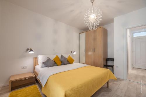 ein Schlafzimmer mit einem gelben Bett und einem Kronleuchter in der Unterkunft Old town apartment Maritta in Zadar
