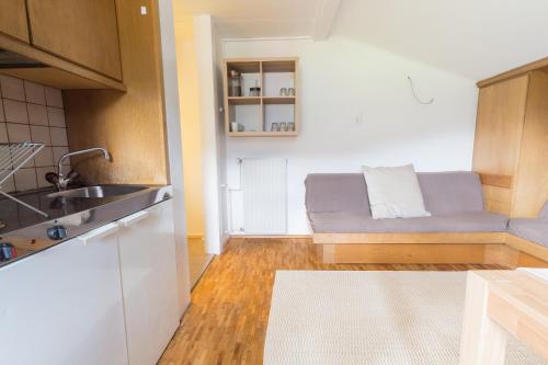 eine Küche mit Sofa und Waschbecken in einem Zimmer in der Unterkunft Arabella Seeappartements in Zell am See