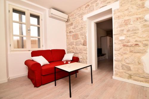 a living room with a red couch and a table at Zadar Small Escape in Zadar