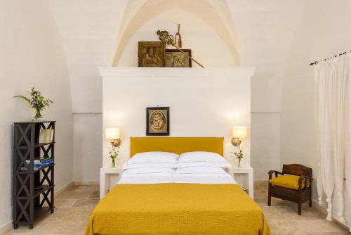 a bedroom with a bed with a yellow blanket at Masseria Marzalossa in Fasano