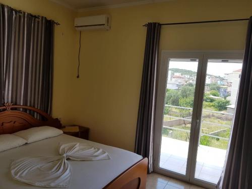 a bedroom with a bed and a sliding glass door at Vila DINI Ksamil in Ksamil