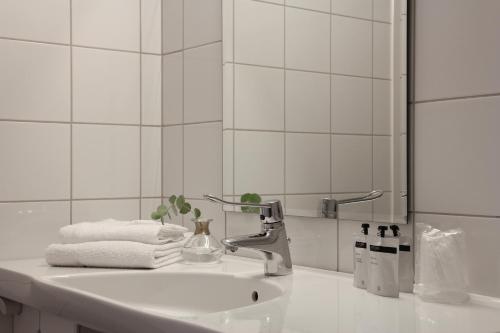 a white bathroom with a sink and a mirror at Brattvåg Fjordhotell in Brattvåg