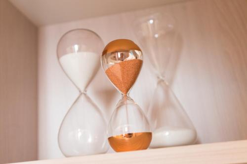 an hourglass sitting on a shelf with other clocks at La Torre del Tempo in Turi