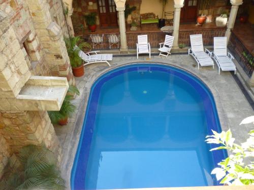 una piscina azul con sillas y una casa en Hotel CasAntica, en Oaxaca City