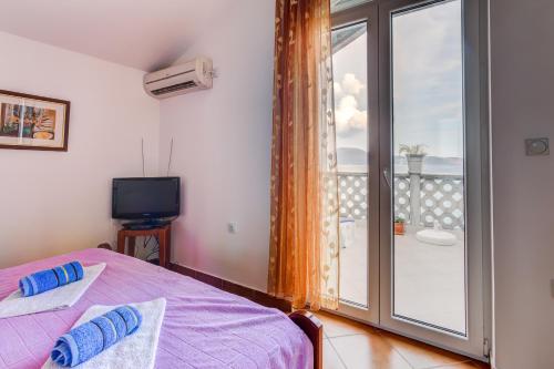 赫爾採格諾維的住宿－Sea Line Apartments，一间卧室设有一张床,阳台配有电视。