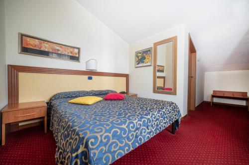 a bedroom with a bed with two pillows on it at Hotel Italia & Lombardi in Montefiascone