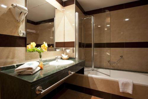 
a bathroom with a tub, sink and mirror at Zimbali Playa Spa Hotel Luxury in Vera

