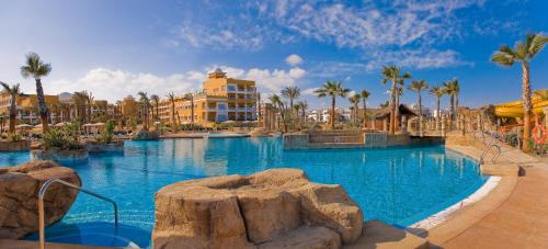 a large swimming pool in a resort with palm trees at Playazimbali in Vera