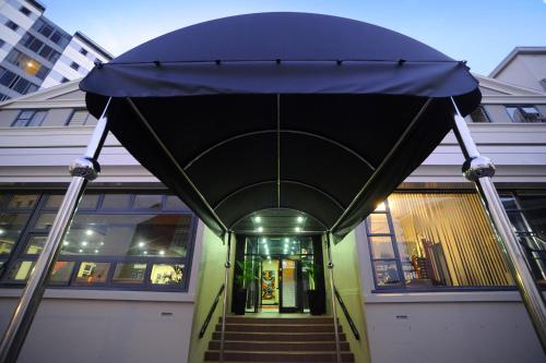 a building with a blue canopy over a stairway at Kiwi International Hotel in Auckland