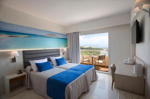 a hotel room with a bed and a balcony at Invisa Ereso All Inclusive in Es Cana