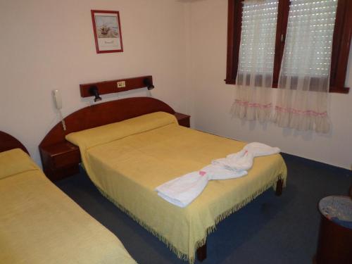 a hotel room with two beds and a window at Hotel Shelter in Mar de Ajó