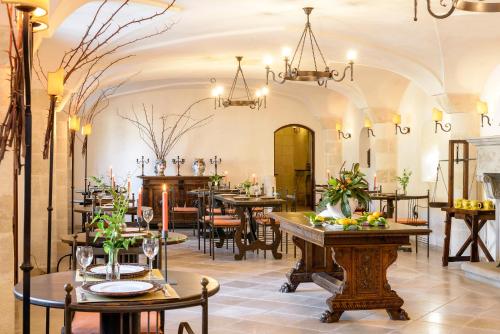 um restaurante com mesas, cadeiras e lustres em Masseria Marzalossa em Fasano