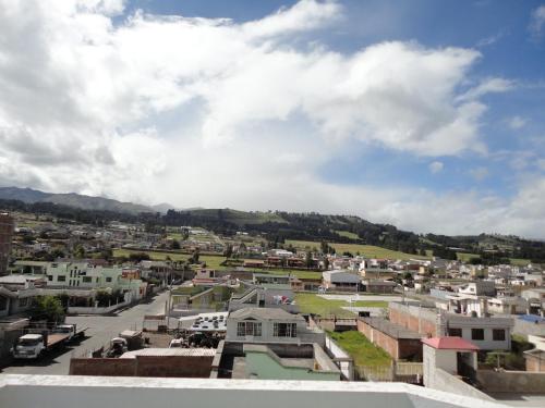 arial view of a city with buildings and mountains at Hostal El Sol de Cayambe in Cayambe
